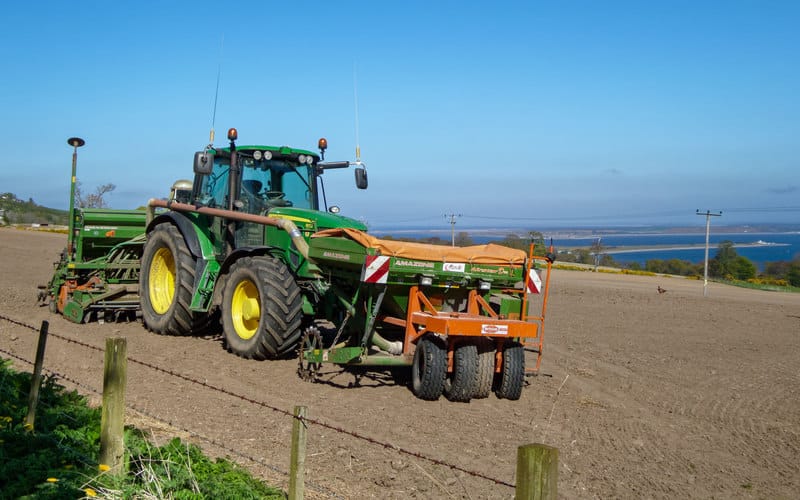 Trator John Deere trabalhando numa plantação